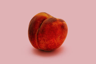 peach sitting on pink background