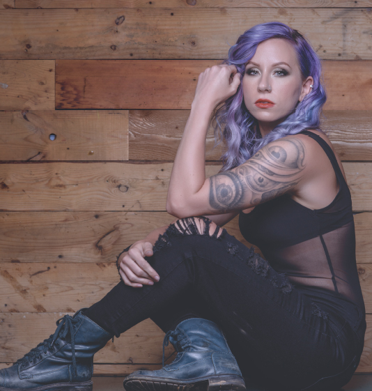 DC Beings model with purple hair, tattoos and black boots